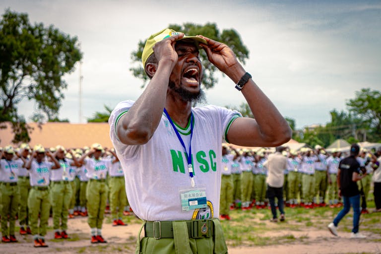NYSC member passionately leads a drill session in Kaduna, Nigeria, showcasing teamwork and youth empowerment.