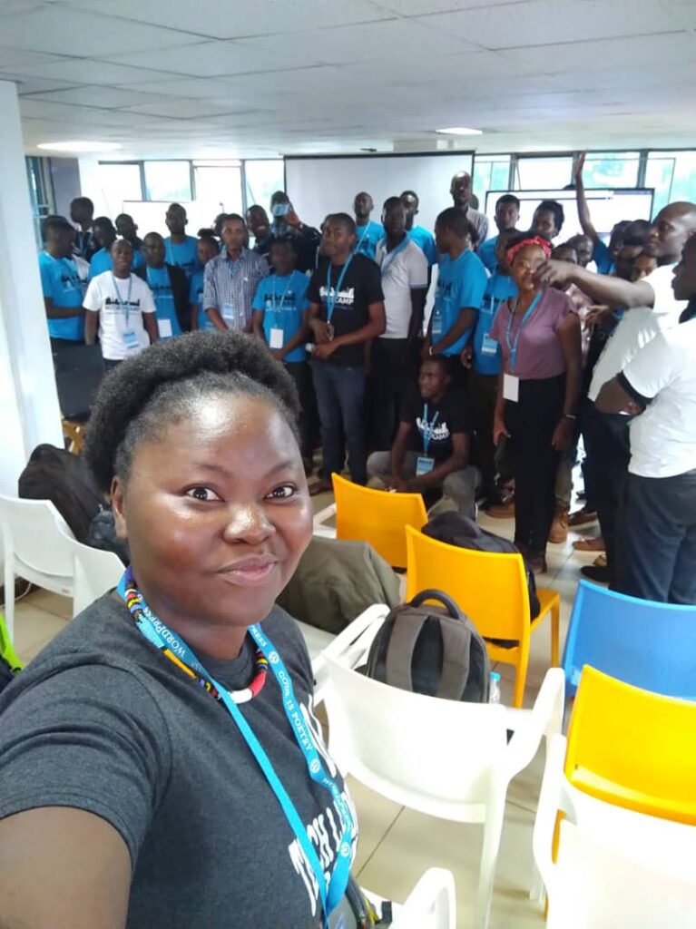 Mary Job speaking at WordCamp Kampala, featured in the People of WordPress profile on WordPress.org